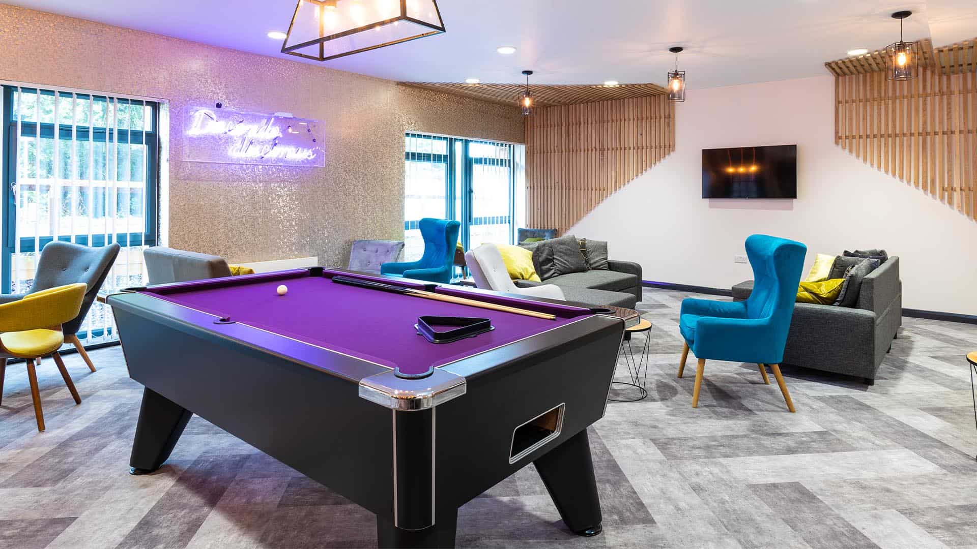 Communal area of Fishbourne accommodation, with a purple pool table in the middle